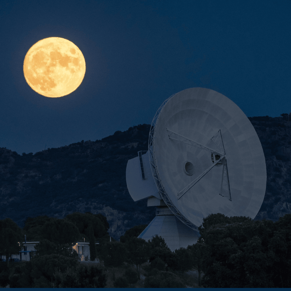 Full moon over a radio telescope at night